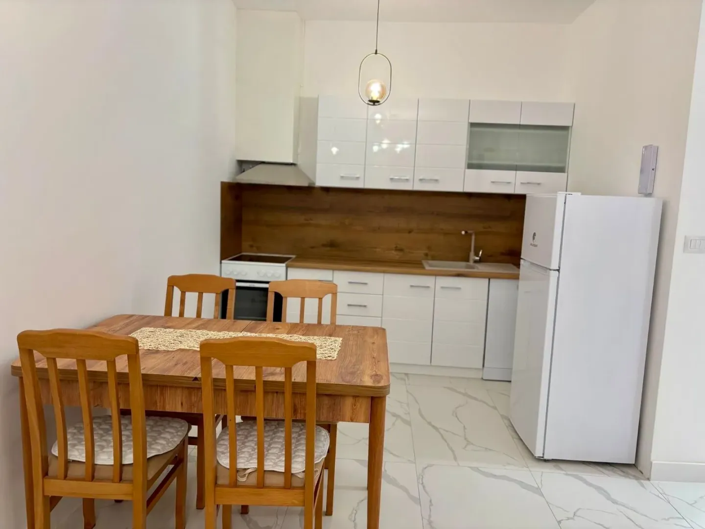 Kitchen with dining area and wooden table.
