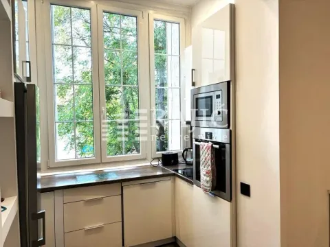 Small bright kitchen with built-in appliances and a window. - image 6