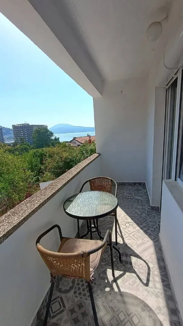Natkrivena terasa sa garniturom za sjedenje i pogledom na more.