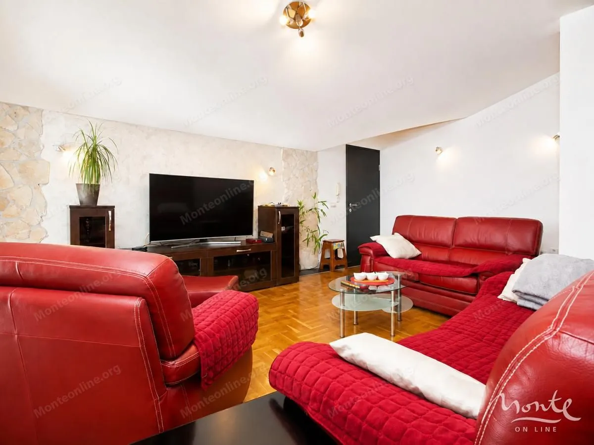 Living room with red leather sofas and a TV.