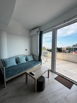 Living room with a sofa, coffee table, and access to a spacious terrace with a view. - image 2