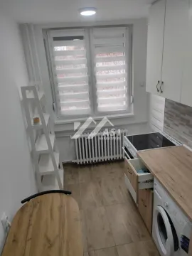 Manja svetla kuhinja sa belim elementima, šporetom i veš mašinom ispod radne ploče. - image 7