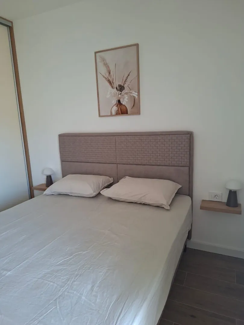 View of a double bed with a headboard and bedside tables in the bedroom.