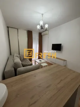 Dnevna soba sa garniturom, TV-om i trpezarijskim stolom u prvom planu. - image 5
