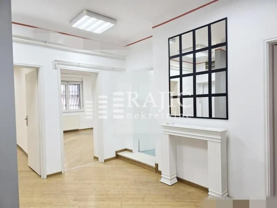 Bright empty room with a decorative fireplace and a wall mirror.