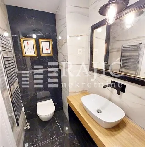 Modern bathroom equipped with a washbasin and black marble tiles.