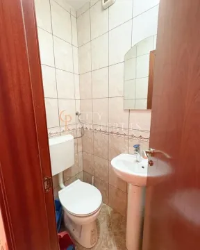 Manje kupatilo obloženo keramičkim pločicama sa toaletom i umivaonikom. - image 3