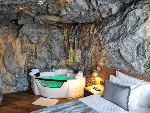 Bedroom featuring a built-in jacuzzi and a natural rock wall. - image 5