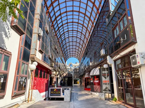 Covered passageway between commercial buildings with a glass roof. - image 9