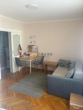 Dnevna soba sa kaučem, trpezarijskim stolom i parketom na podu. - image 4