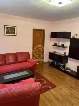 Living room with red leather sofa set and TV unit. - image 2