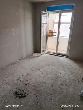 Prazna prostorija u sivoj fazi izgradnje sa balkonskim vratima. - image 2