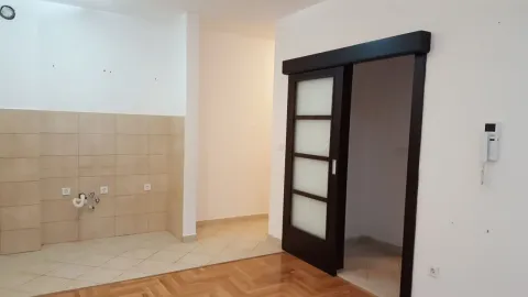 An empty room with kitchen utility connections and a sliding door. - image 4