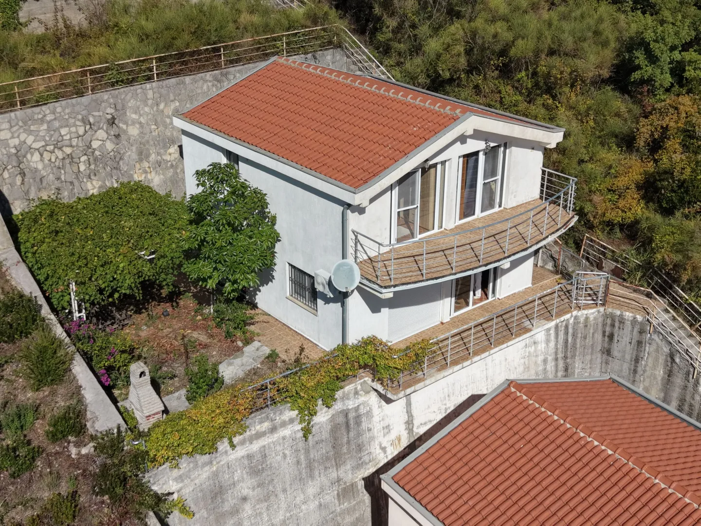 Aerial view of a two-story house with a yard and terrace.