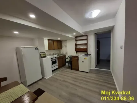 Kuhinja sa drvenim elementima, frižiderom i šporetom. - image 4