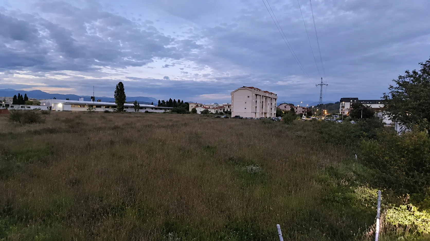 Pogled na plac i okolne zgrade u sumraku.