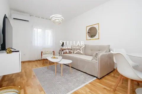 Living room with sofa, coffee table, and television. - image 2