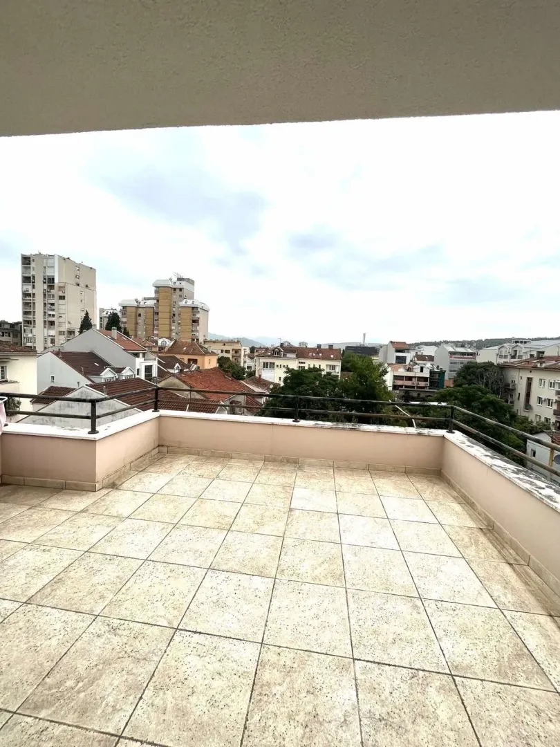 Prostrana otvorena terasa sa pogledom na grad.