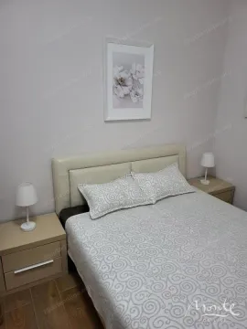 Namještena spavaća soba sa bračnim krevetom, noćnim stočićima i slikom na zidu. - image 5