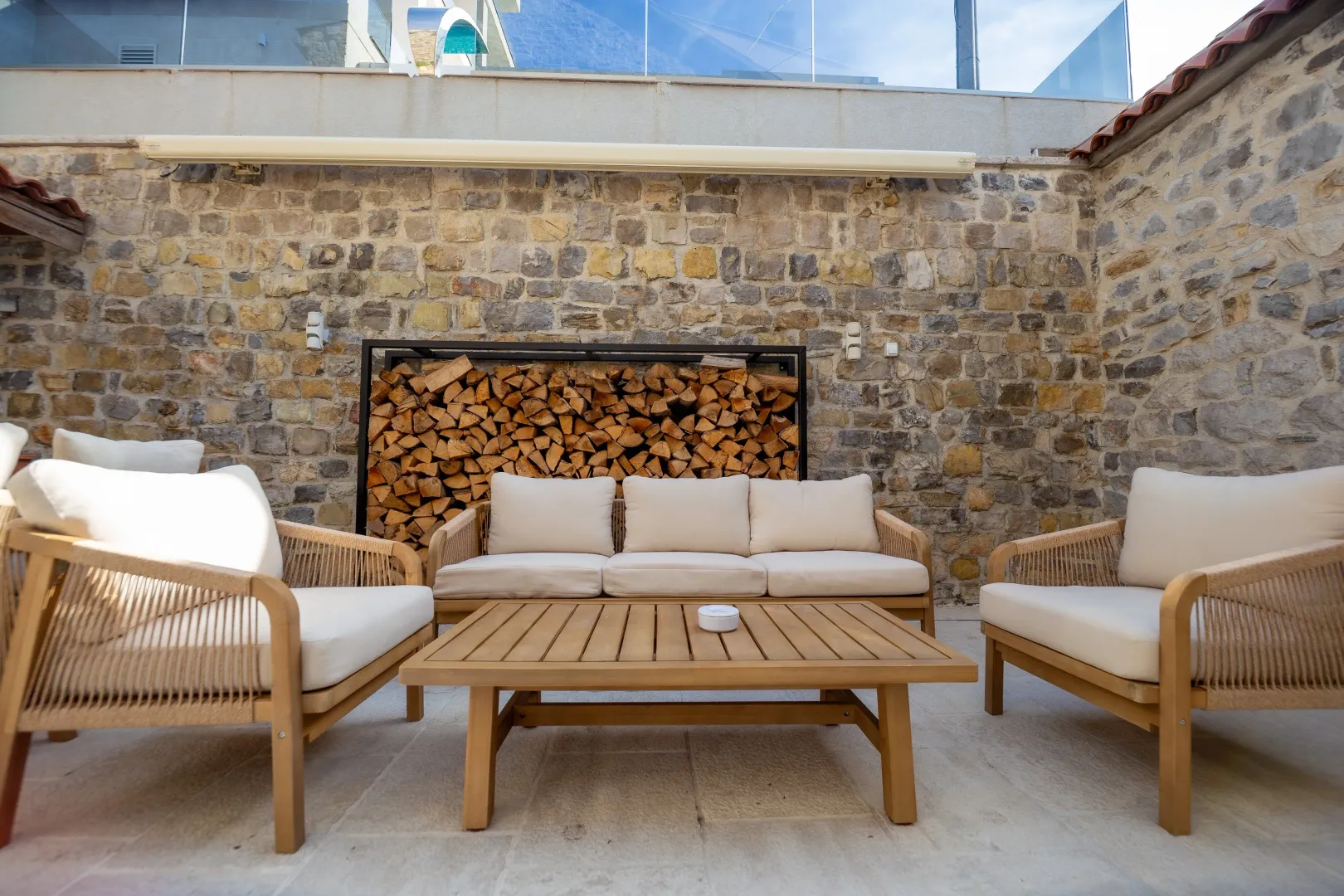Furnished courtyard with seating furniture and a stone wall.