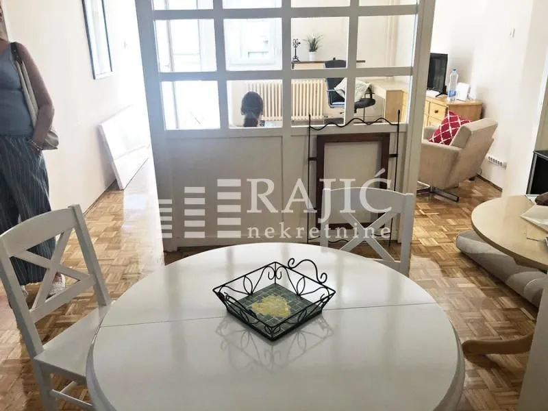 Living room with a dining table and a glass partition.