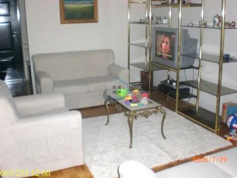 Dnevna soba sa garniturom za sedenje, policama i televizorom. - image 3