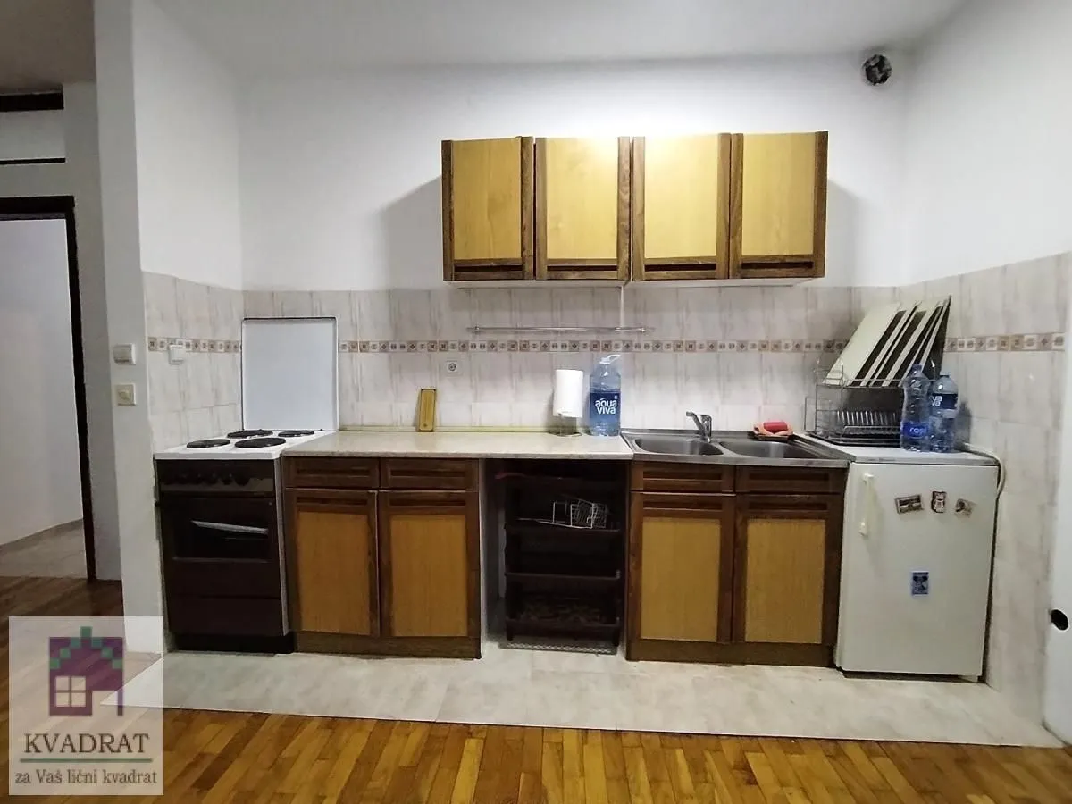 Small kitchen with wooden cabinets, stove, and refrigerator.