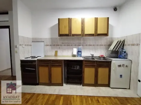 Small kitchen with wooden cabinets, stove, and refrigerator. - image 4