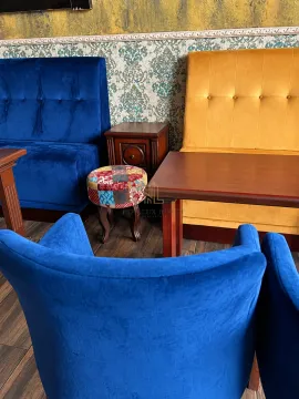 Living room with colorful upholstered furniture and a wooden coffee table. - image 5