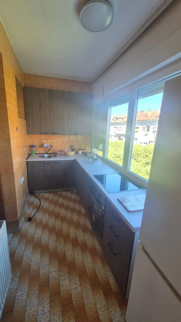 Small kitchen with dark cabinets and a large window.