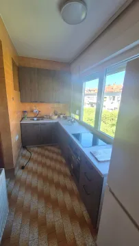 Small kitchen with dark cabinets and a large window. - image 9