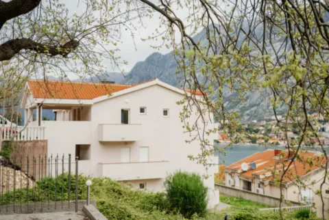 Spoljni izgled stambene zgrade sa pogledom na more i planine u pozadini. - image 11