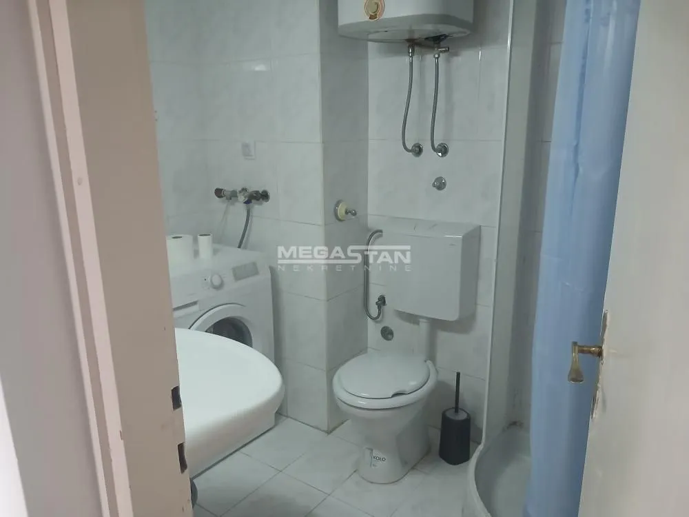 Manje kupatilo sa sanitarijama, tuš kabinom i veš mašinom.