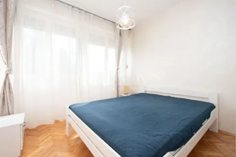 Bright bedroom with a double bed, parquet flooring, and a large window with curtains. - image 4