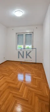 Prazna soba sa bijelim zidovima i drvenim parketom. - image 4