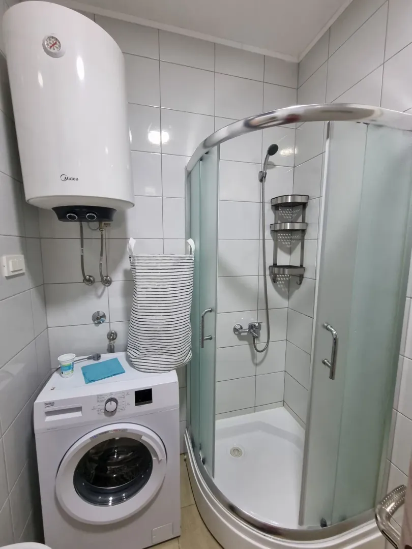 Kupatilo opremljeno tuš kabinom, mašinom za veš i bojlerom.