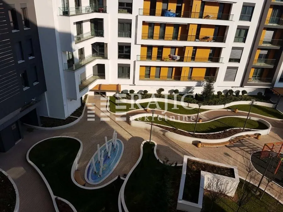 Aerial view of the courtyard and facade of a residential building with landscaped greenery.