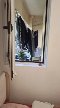 Pogled kroz otvoreni prozor na balkon sa okačenim vešom. - image 10