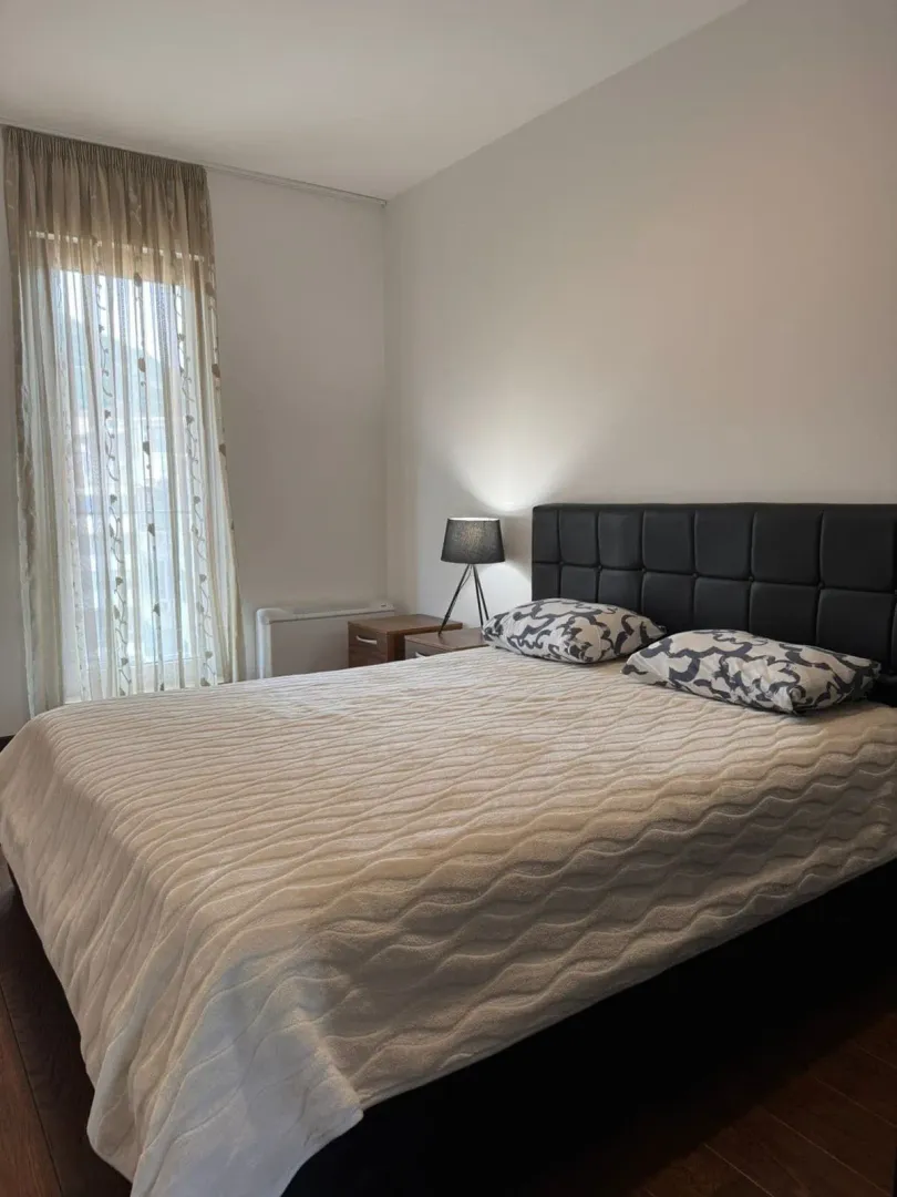 Bright bedroom with a double bed and a nightstand.