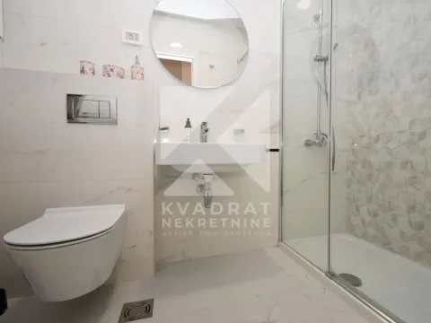 Modern bathroom with a shower cabin, washbasin, and built-in toilet. - image 3
