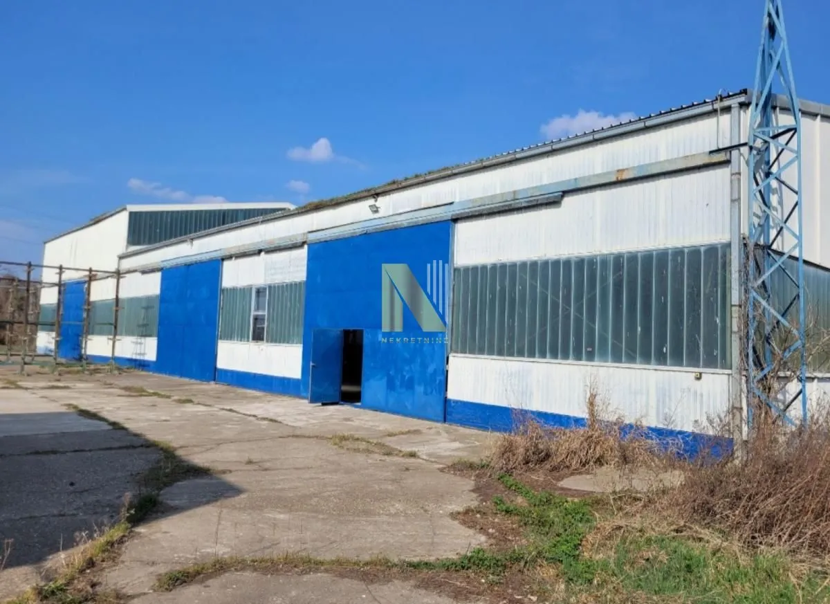 Exterior view of an industrial building with blue sliding doors.
