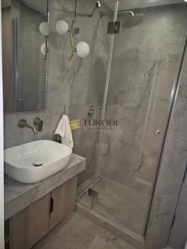 Savremeno opremljeno kupatilo sa umivaonikom i tuš kabinom. - image 2