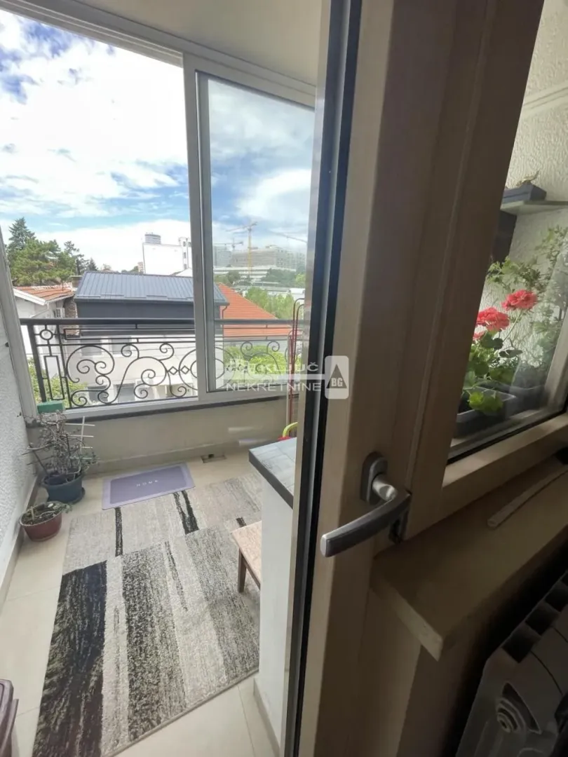 View of the balcony with glass doors and a rug on the floor.