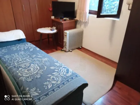Jednostavna spavaća soba sa jednim krevetom i televizorom. - image 6