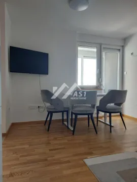 Dnevna soba sa trpezarijskim stolom, stolicama i televizorom na zidu. - image 4