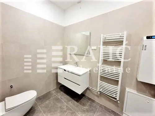Modern bathroom with a sink, mirror, and white towel radiator.