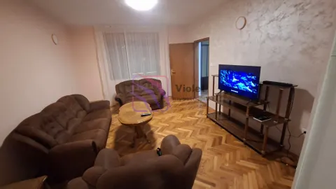 Living room with a sofa set, coffee table, and television on a stand. - image 5