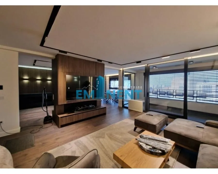 Spacious living room with modern furniture and a TV panel.