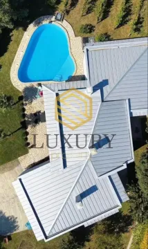 Aerial view of a house with a swimming pool and yard. - image 4