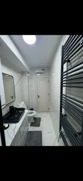 Moderno opremljeno kupatilo sa bijelim mermernim pločicama i crnim detaljima. - image 10